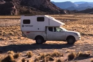 Mitsubishi L200 camper 4x4 de TomyKat equipada para overlanding, con célula habitable y accesorios de expedición en plena naturaleza