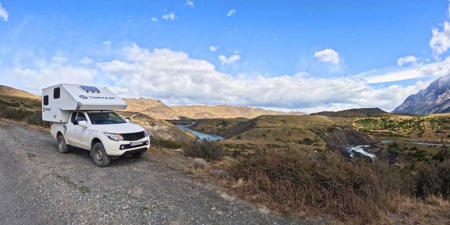 vehículo 4x4 recorriendo una carretera remota en Argentina con rio y paisajes
