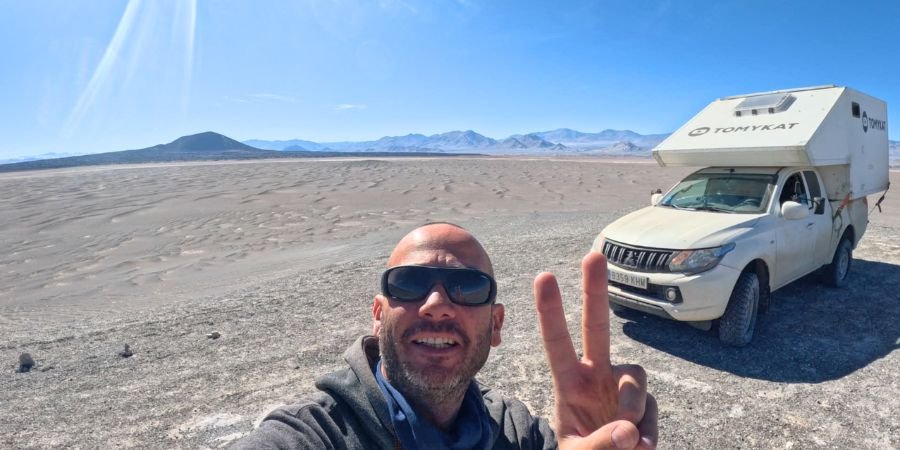 Viajero overland Tomykat junto a su vehículo 4x4 en el campo de piedra pomes Argentina
